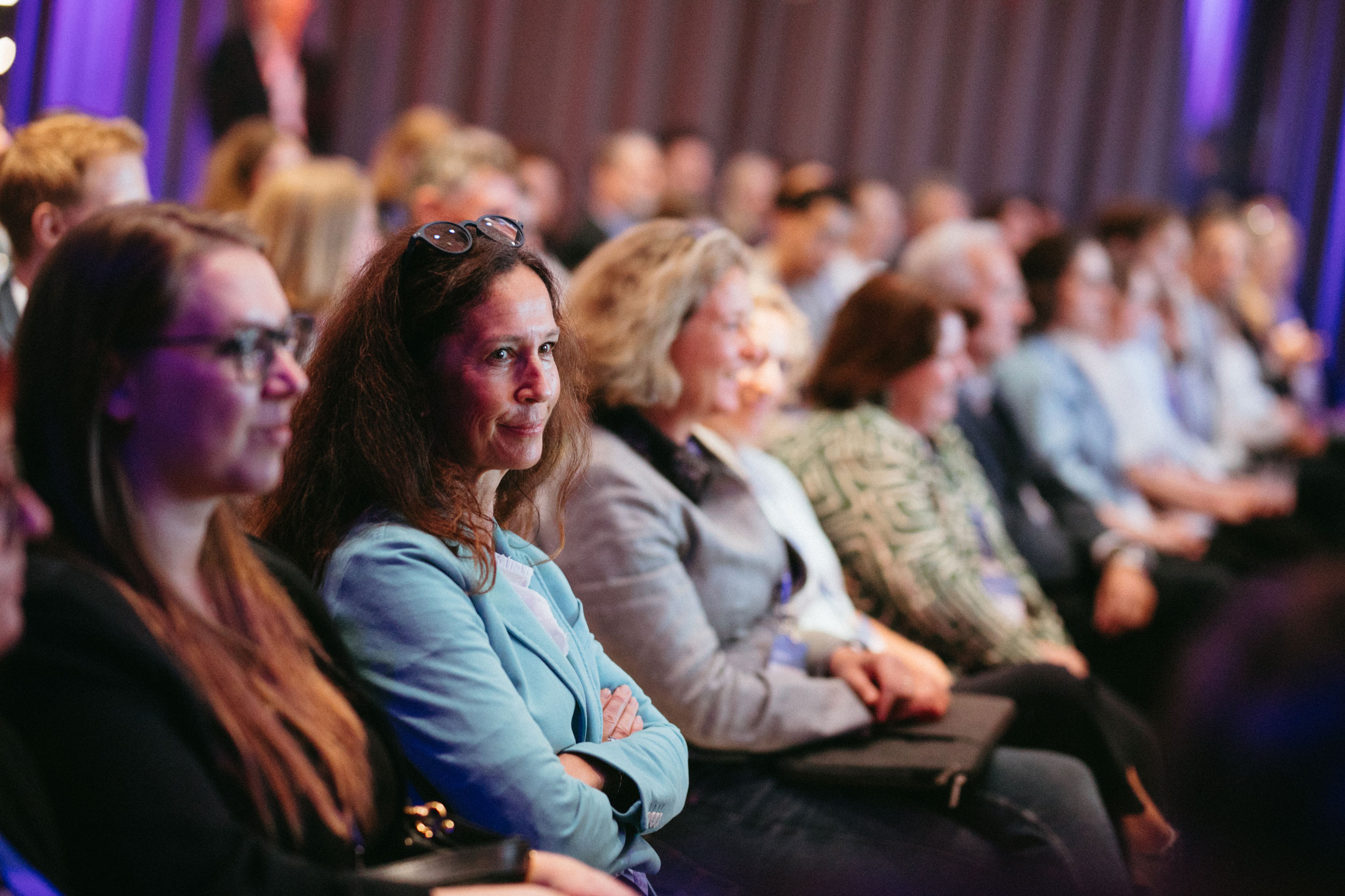Menschen sitzen in deinem Konferenzraum und hören dem Vortrag zu.