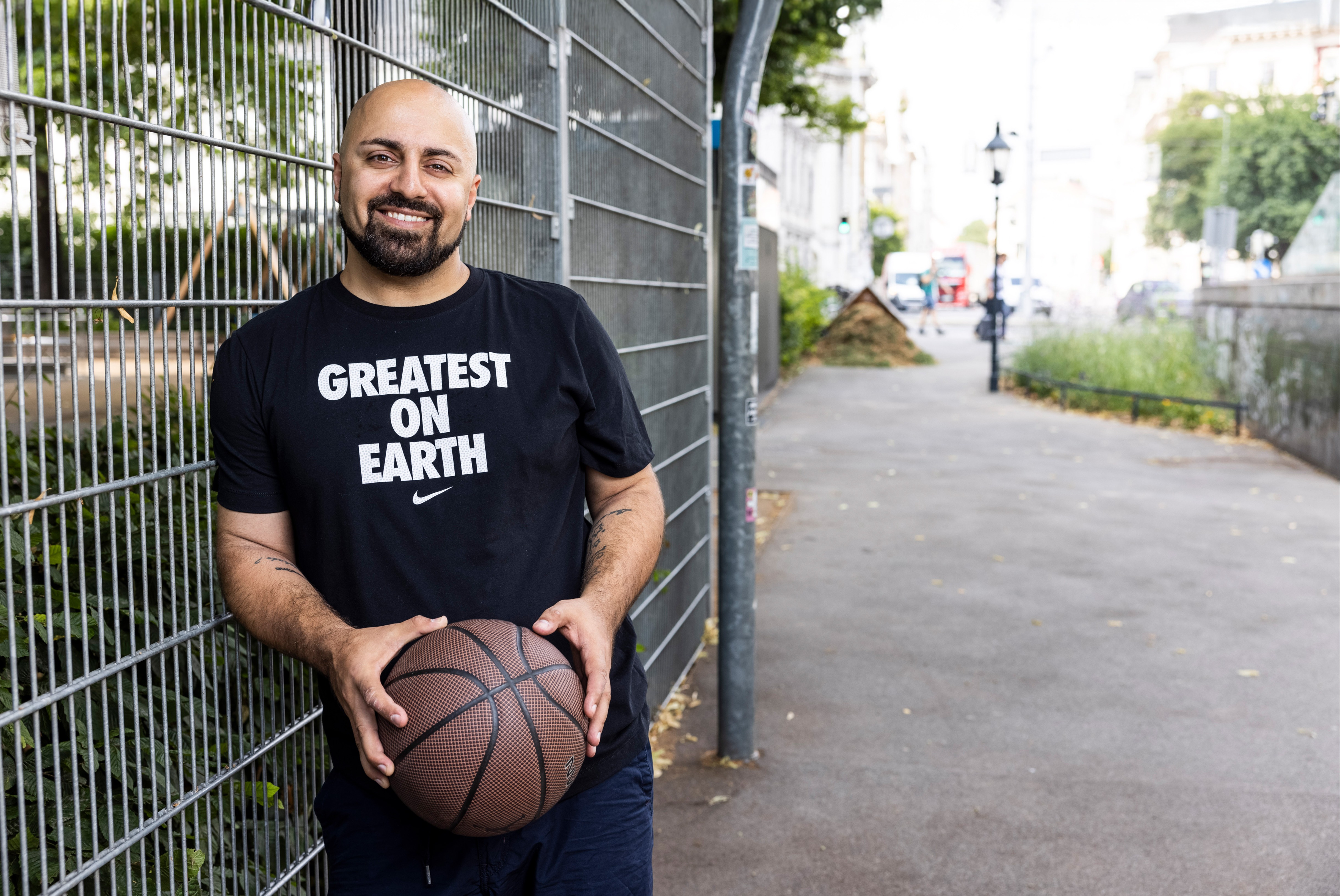 Der österreichisch-persische Bestseller-Autor, internationale Keynote Speaker und Unternehmer sowie CEO von futureOne Ali Mahlodji sitzt auf einem Hocker vor grauem Hintergrund. Er hat die Hände vor sich zusammengeschlagen und lächelt. 