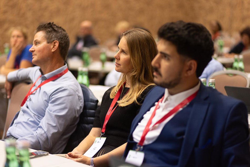 Blonde Frau Und Zwei Männer Im Publikum einer Konferenz