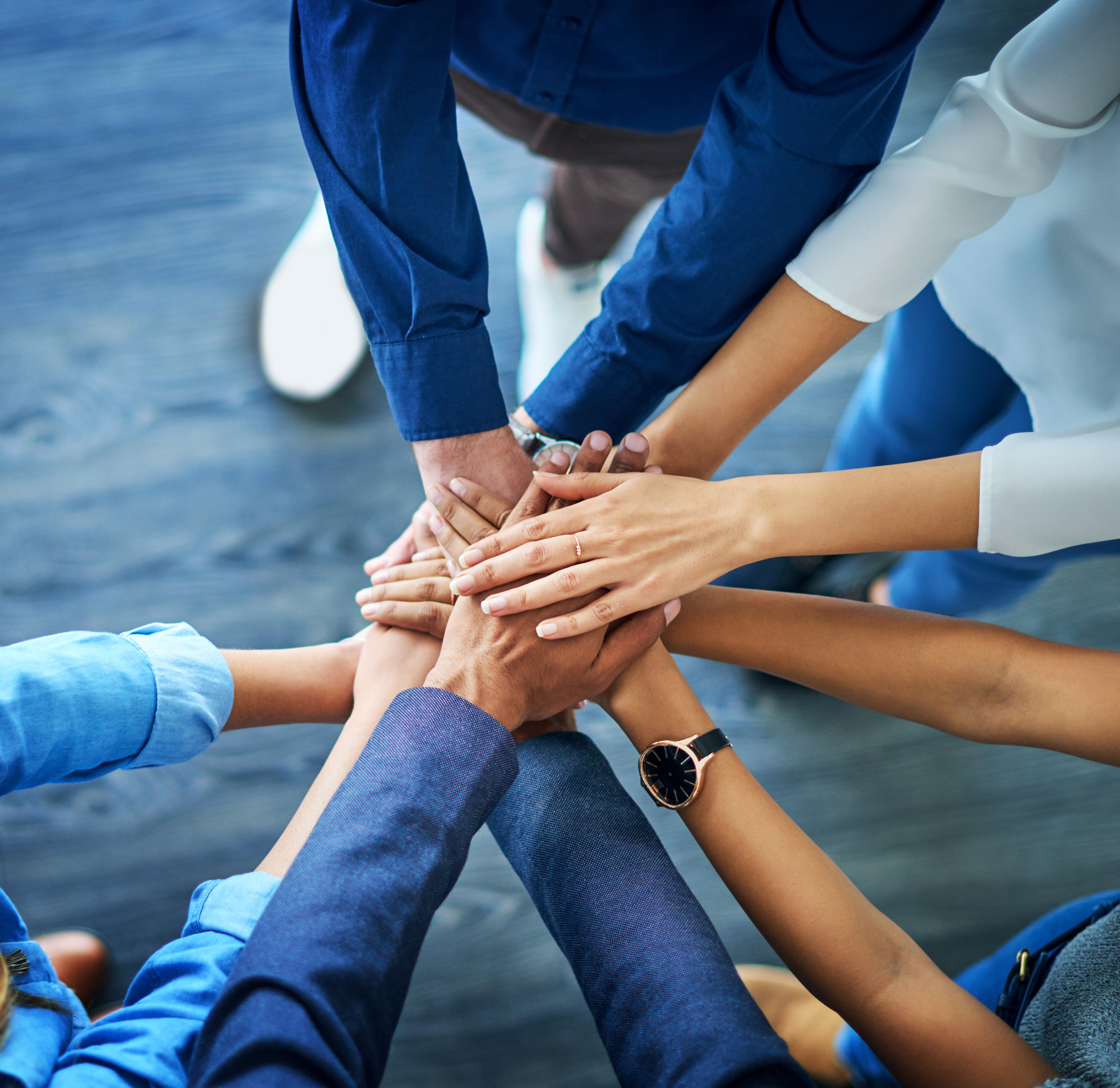 Hände, die aufeinander legen und Teamwork darstellen