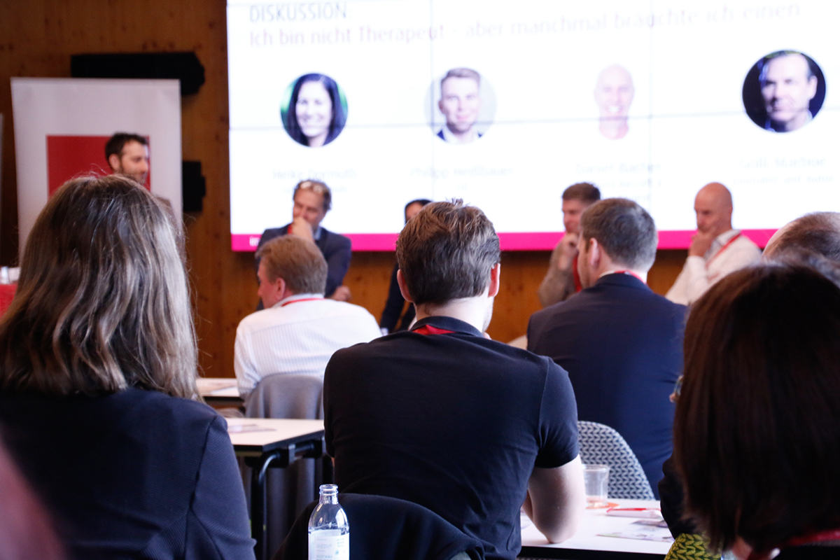 Publikum und Diskussionsrunde bei der Konferenz "Lehrlingsausbildung 2026"