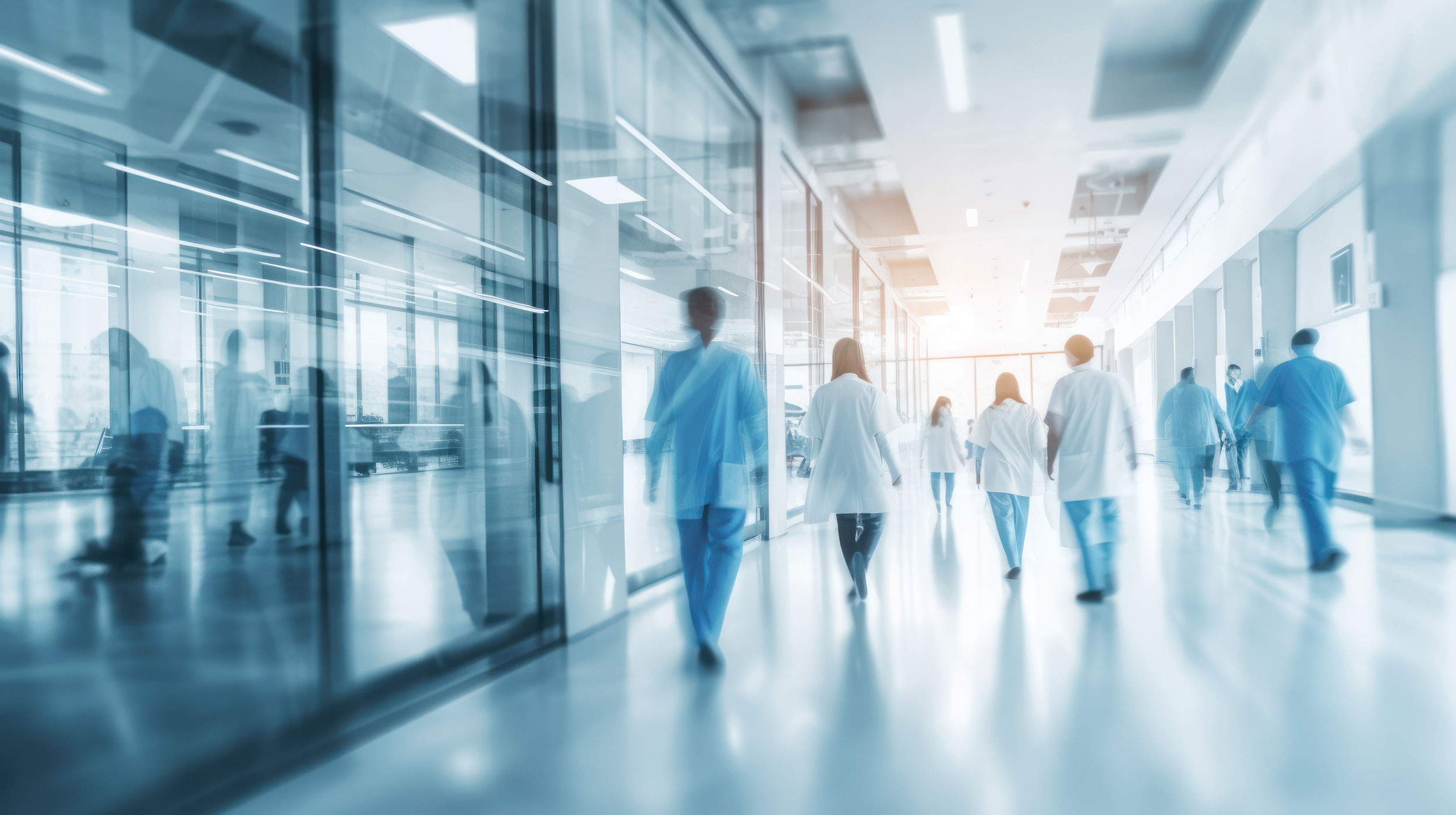 Krankenhauspersonal geht einen Krankkausflus entlang.