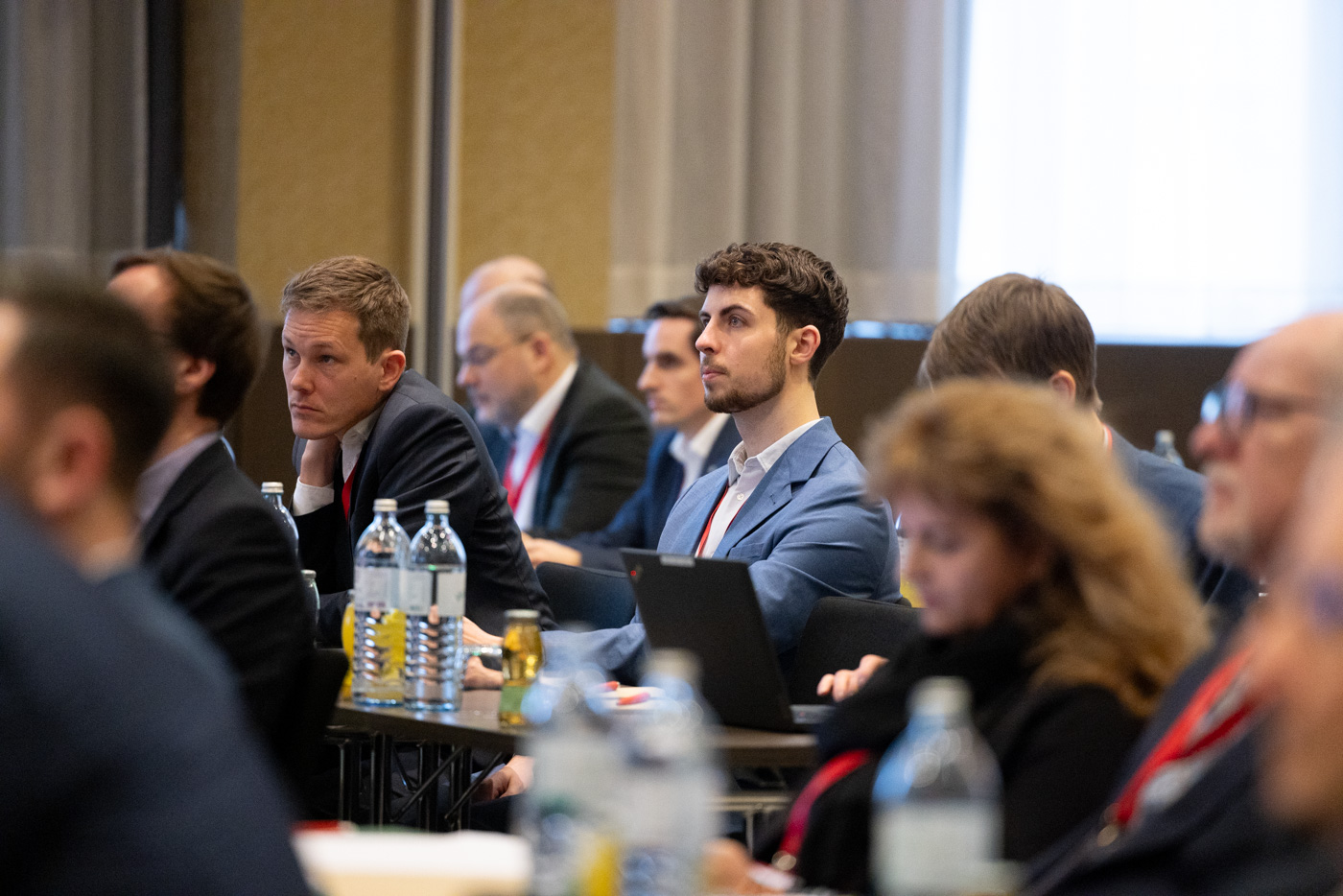 Mehrere Personen sitzen in einem Konferenzraum und hören gespannt zu