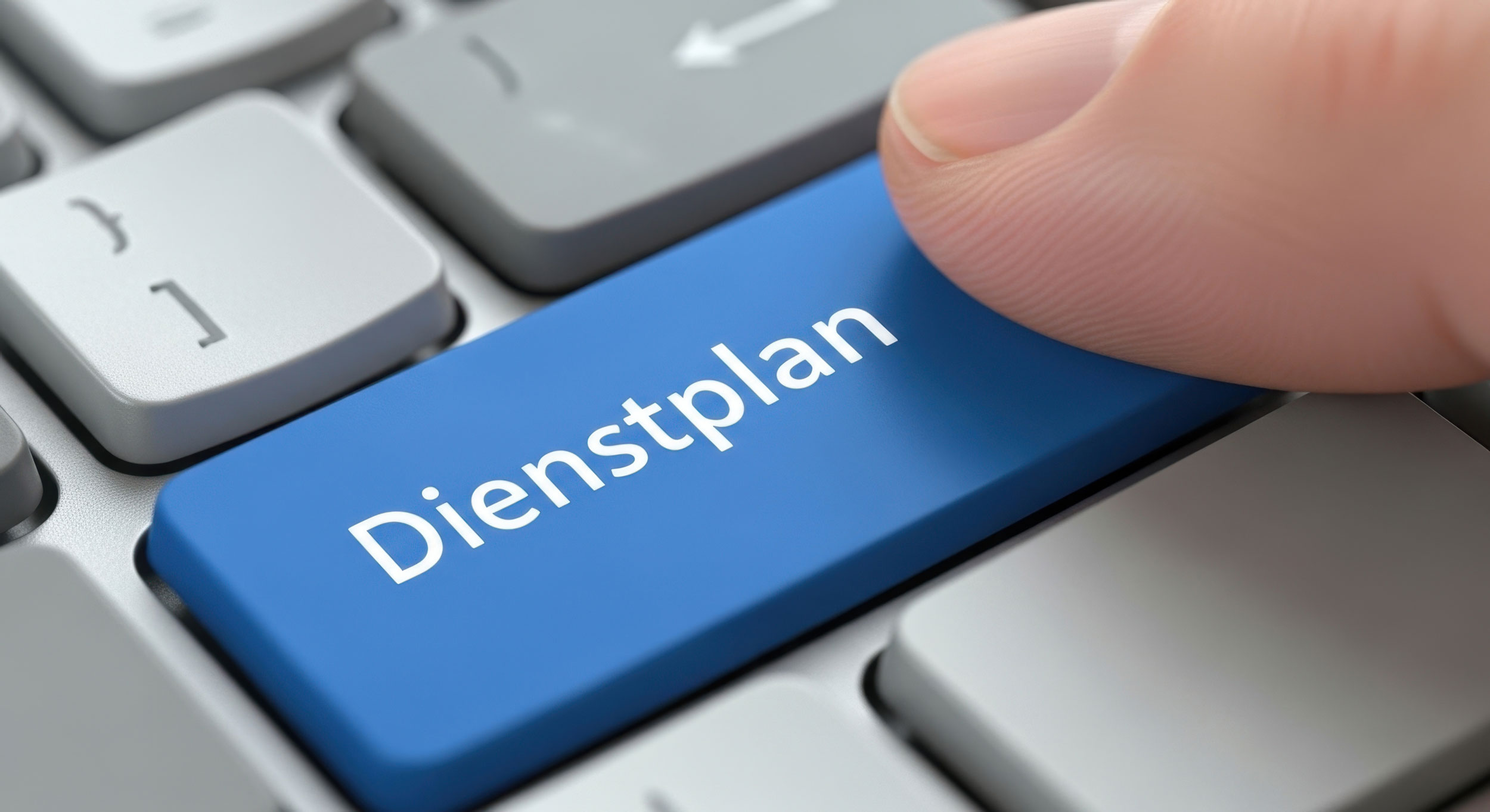 Ein Finger tippt auf die Taste einer Tastatur auf der Dienstplan steht.