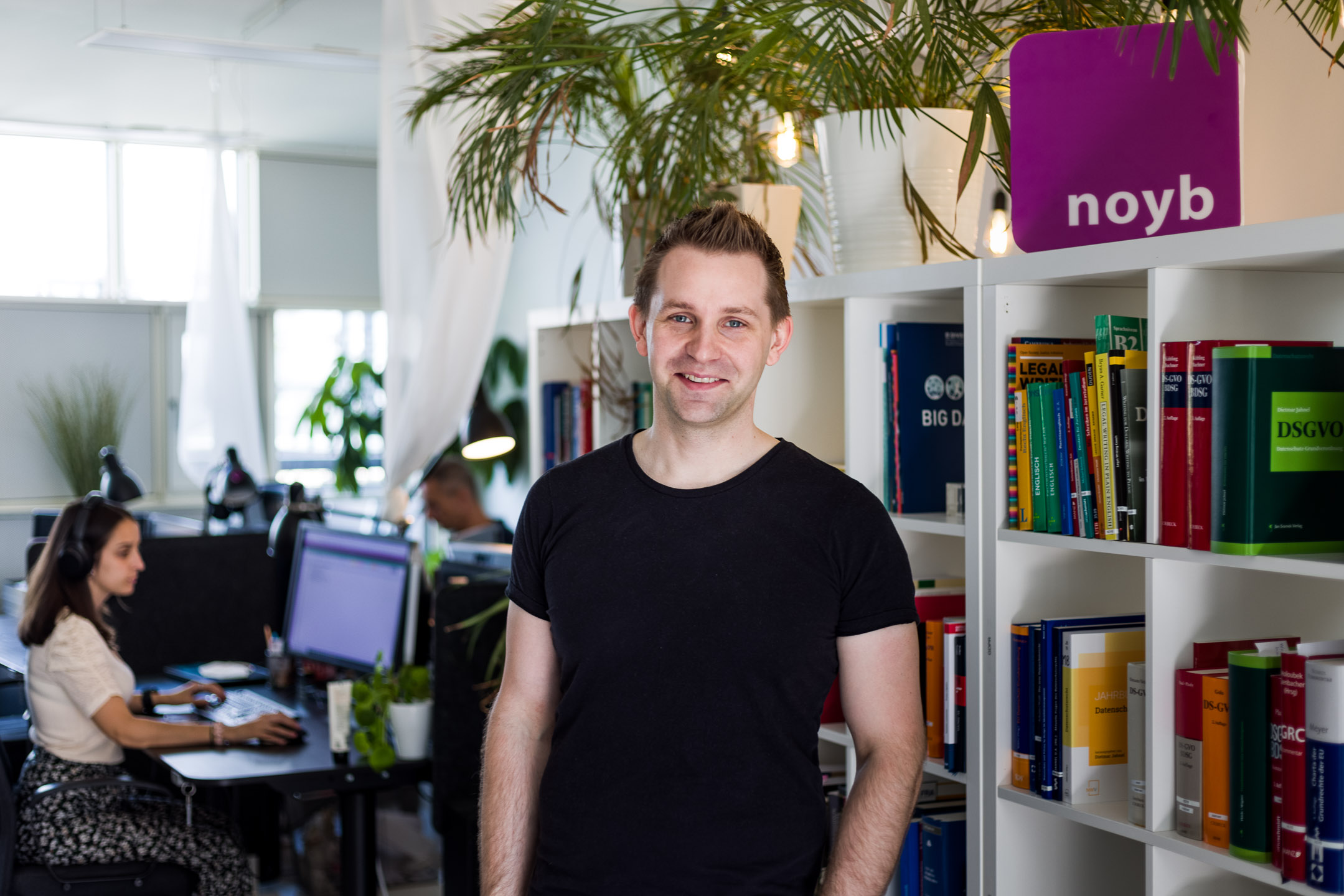 Max Schrems steht in seinem Büro vor einem Bücherregal.
